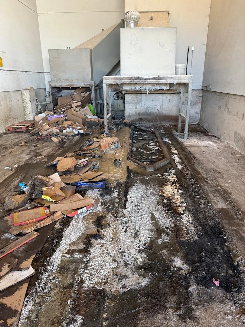 Greasy and littered compactor pad before pressure washing by GPM Cleaning Services in the GTA