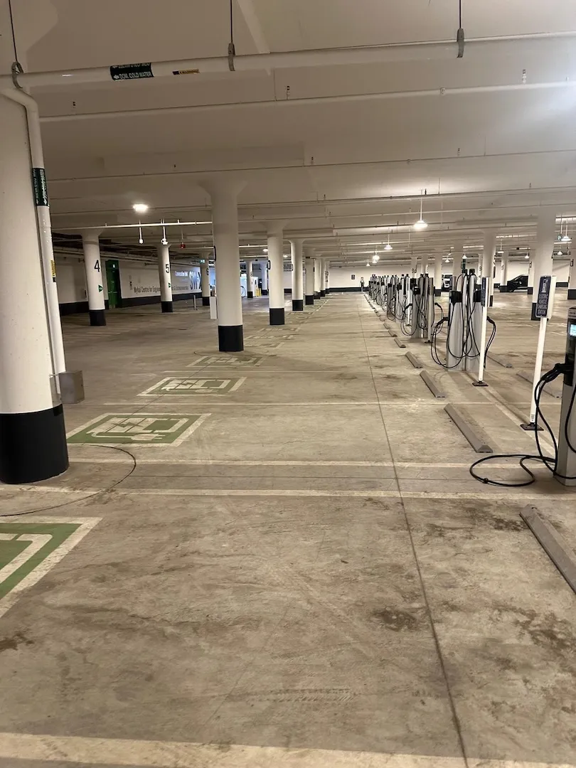 Grimy EV charging zone before professional pressure cleaning